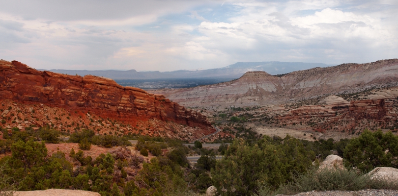 [Canyons walls from a distance appear they will cross each other but the roadway can be seen to go around and through this area. Two photos were stitched together to create this view.]